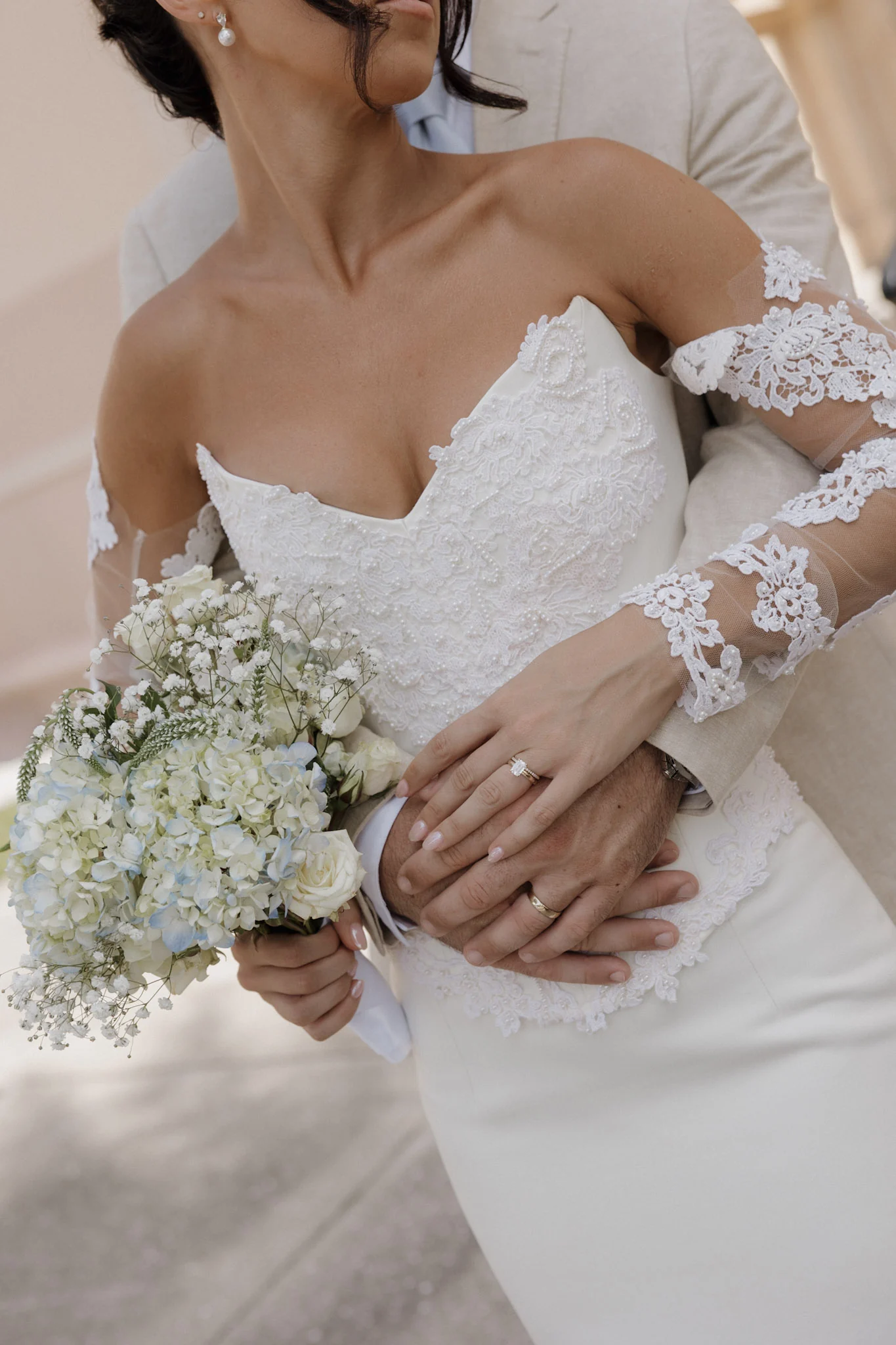 Bride holding a white floral bouquet in her wedding dress