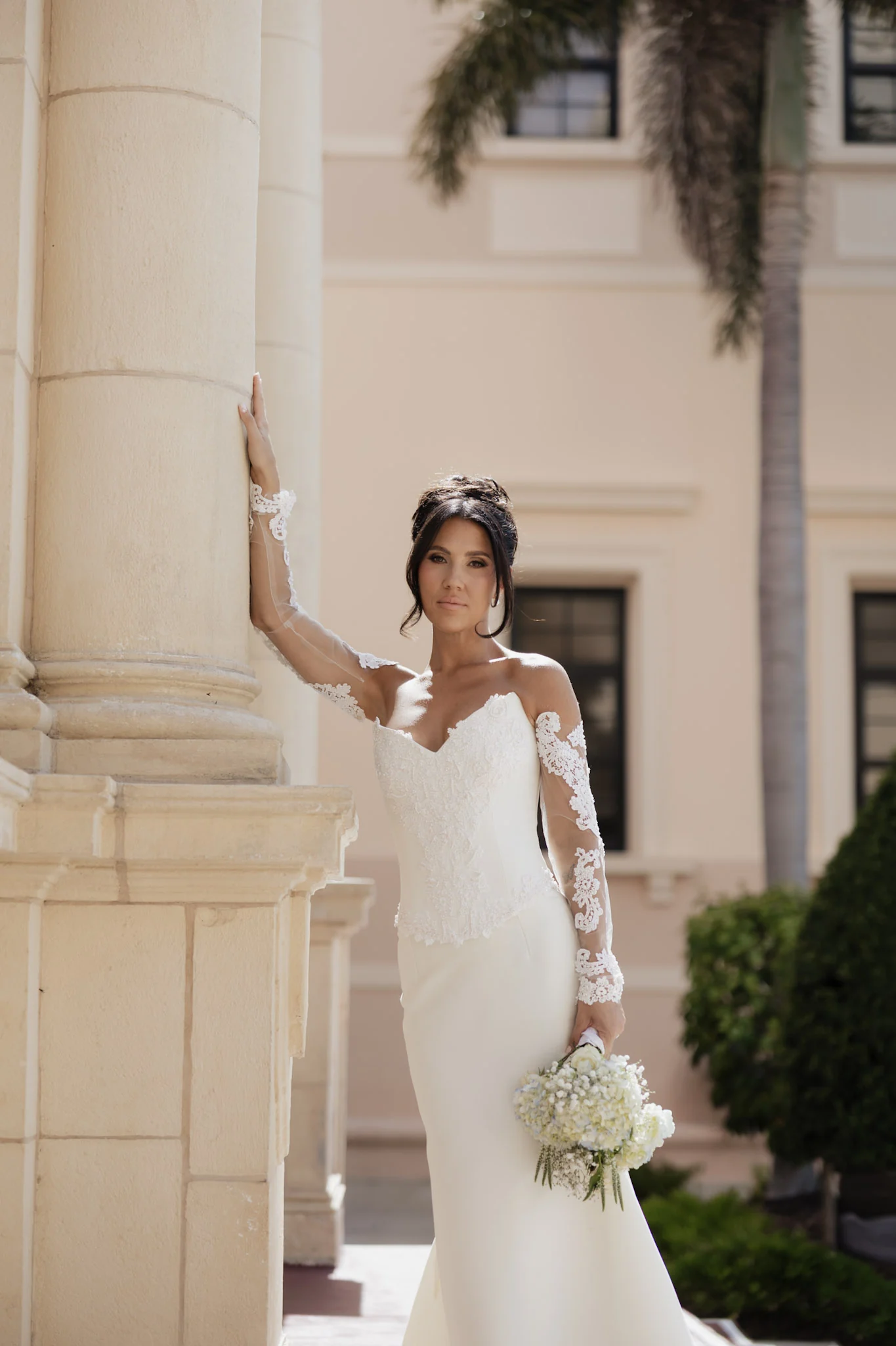 Bride posing beside white columns