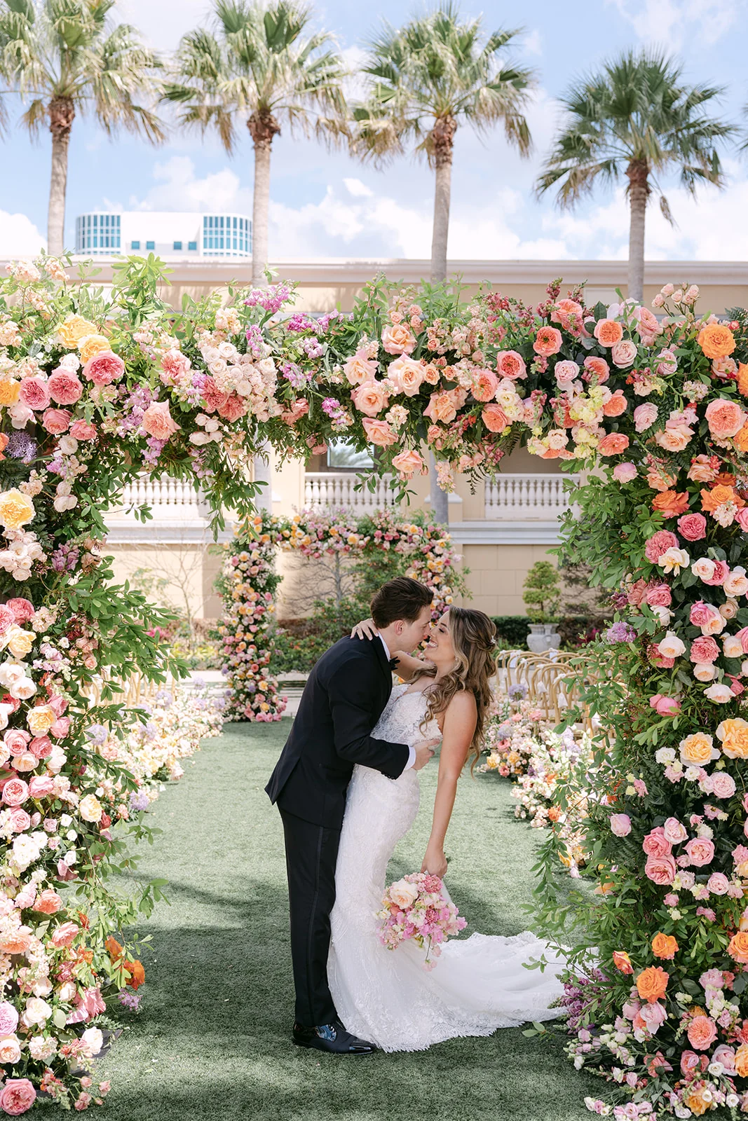 Bride walking through floral wedding ceremony decor