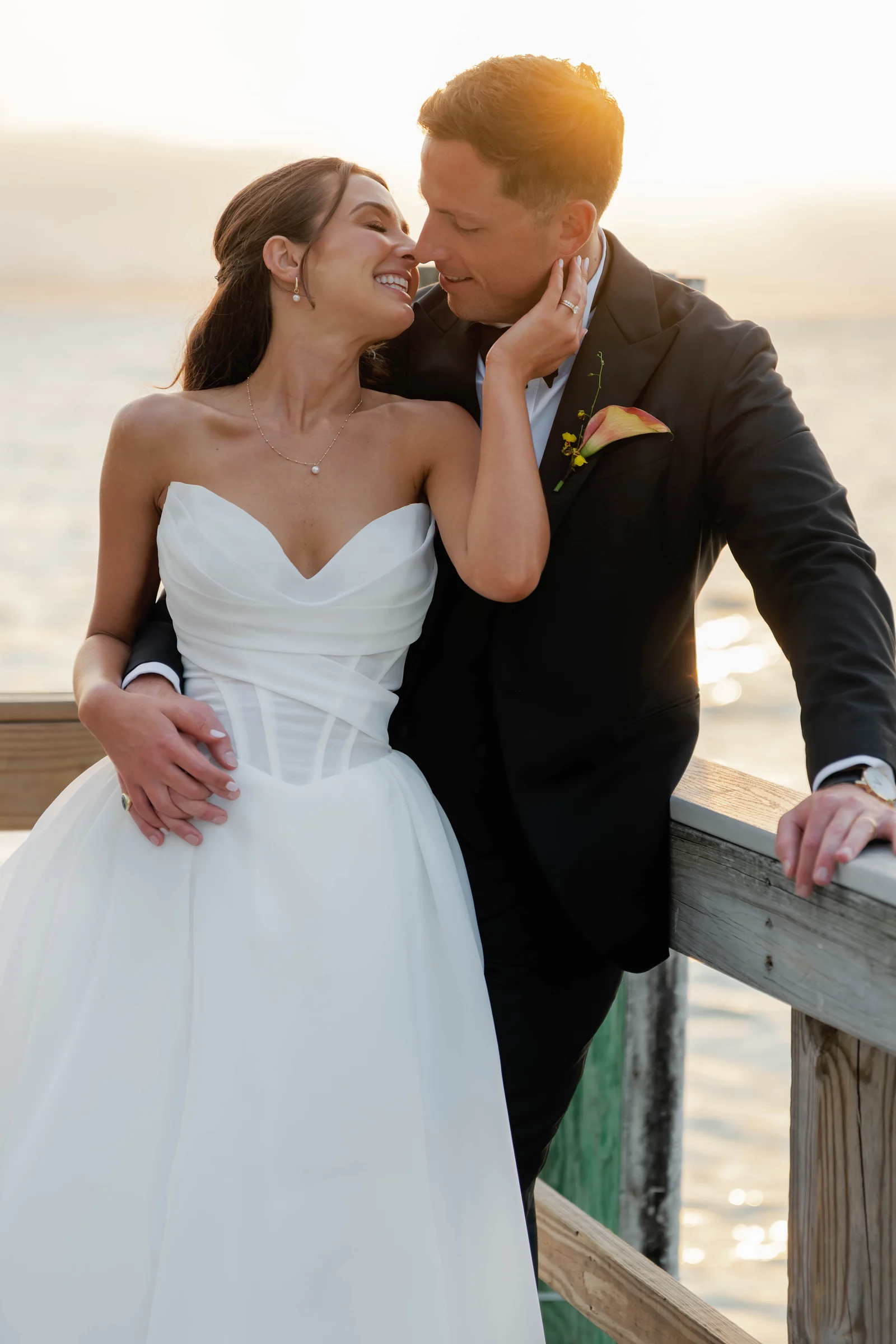 Bride and groom embracing at sunset