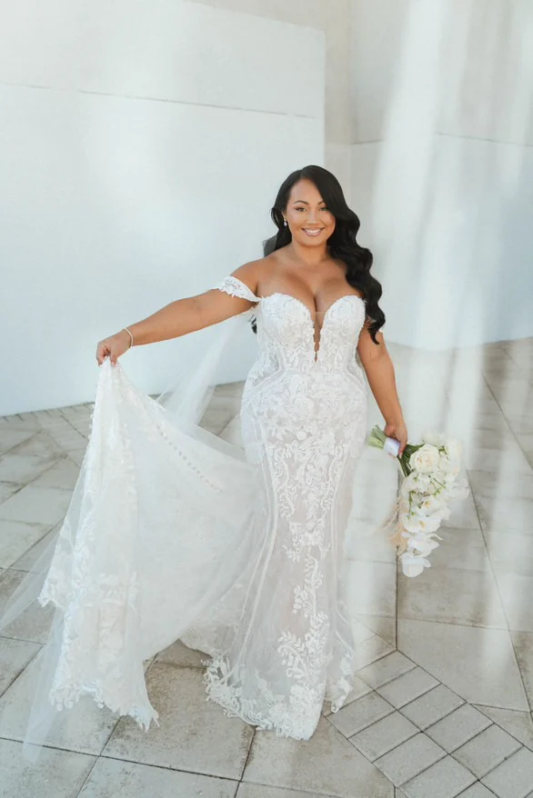 Bride posing against white Mediterranean-style architecture